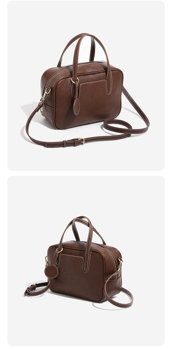 Structured boxy bowling-style tote bag in deep brown leather-look finish with dual top handles, front slip pocket, round