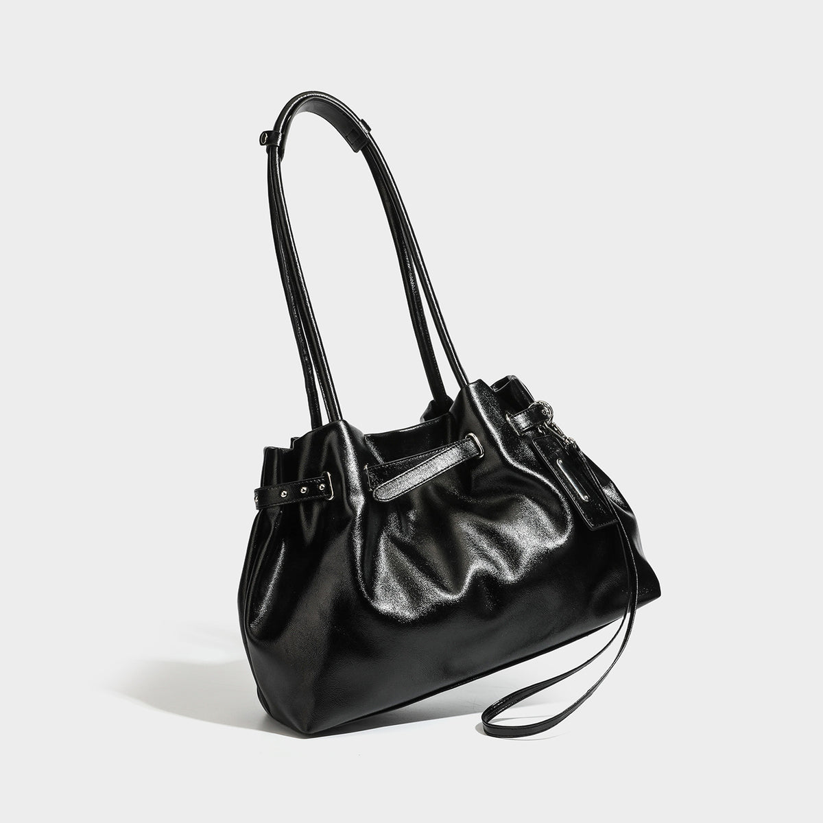 Glänzende schwarze lässige Schultertasche mit gerafftem oberen Rand, zwei langen Riemen, Beschlägen in Silberoptik und abnehmbarem Crossbody-Riemen