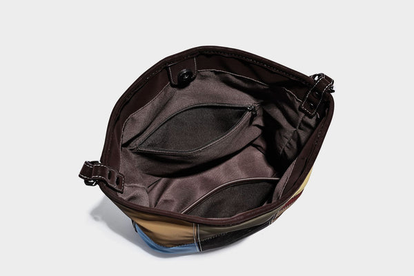Weich fallende Patchwork-Bucket-Schultertasche mit Einsätzen in Dunkelbraun, Cognac, Senfgelb, Olivgrün, Rot und Hellblau sowie Kontrastnähten