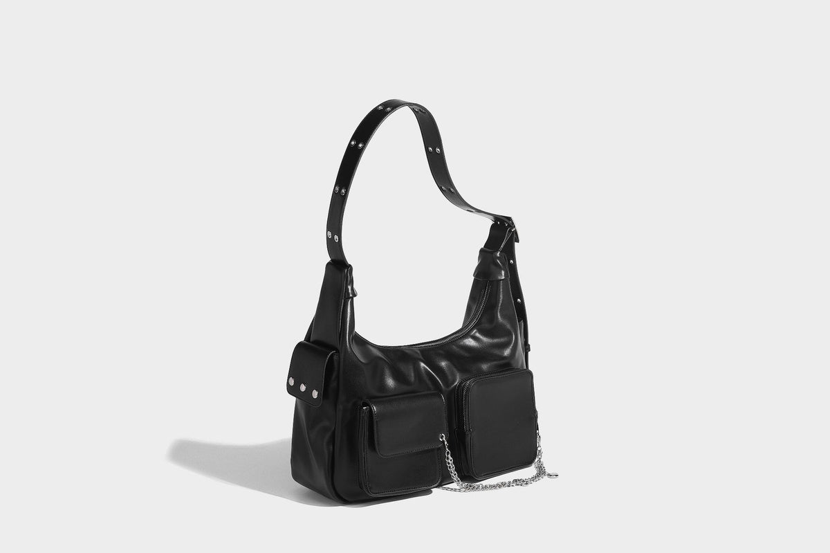 Lässig fallende Hobo-Schultertasche mit glänzender Lederoptik, vorderen Klappentaschen, Kettenapplikationen und silberfarbenen Nietbeschlägen