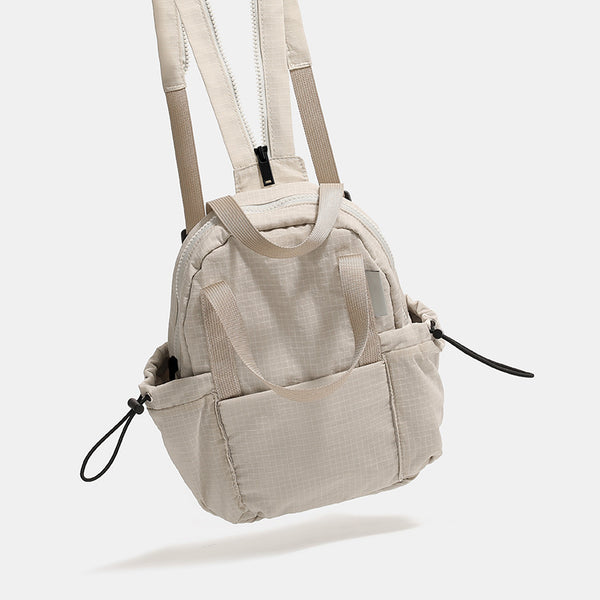 Mini rounded convertible backpack handbag in matte ripstop fabric with dual top handles, adjustable straps, and side, detail