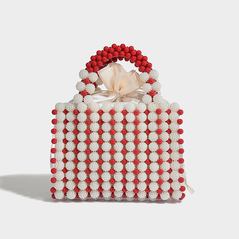 Small boxy pearl-bead mini top-handle bag with silver metallic bead accents, satin floral detail, and long beaded shoulder