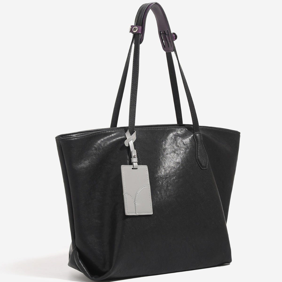Oversized slouchy leather-look tote bag with long shoulder straps, contrast grey hanging tag, and silver-tone hardware