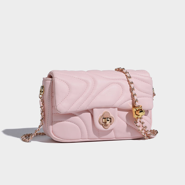 Compact cream quilted flap crossbody bag with wave stitching, gold-tone chain strap, and four-petal turn-lock clasp, detail