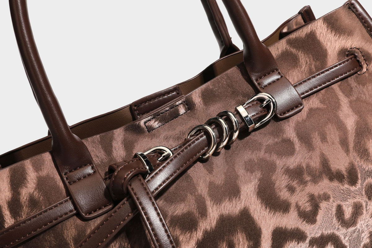 Structured leopard-print tote bag with glossy satin-like finish, dual rounded top handles, silver buckle-and-ring front