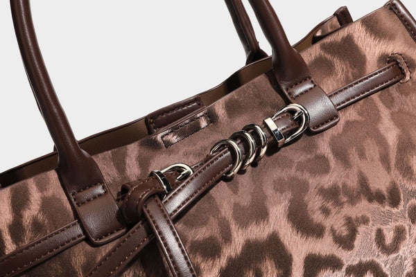 Structured leopard-print tote bag with glossy satin-like finish, dual rounded top handles, silver buckle-and-ring front