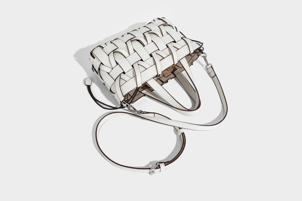Structured woven basket tote handbag with contrasting dark trim, double top handles, detachable shoulder strap, and