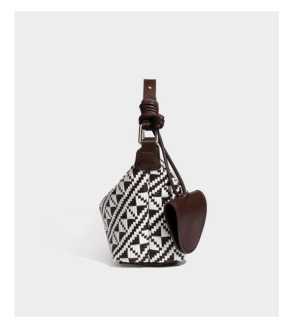 Kleine schwarz-weiße Schultertasche mit gewebtem geometrischem Muster, glatter dunkelbrauner Besatz aus Lederoptik, geknotetem verstellbarem Riemen und seitlichem