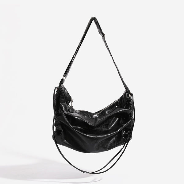 Oversized slouchy hobo shoulder bag with glossy crinkled leather-look finish, drawstring gathered sides, and silver-tone