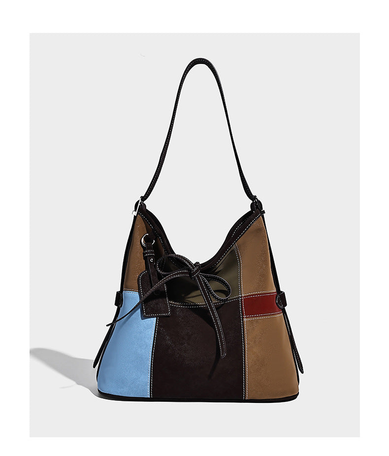 Patchwork bucket tote shoulder bag with tan, dark brown, olive, red, and sky blue color-block panels, white contrast, detail