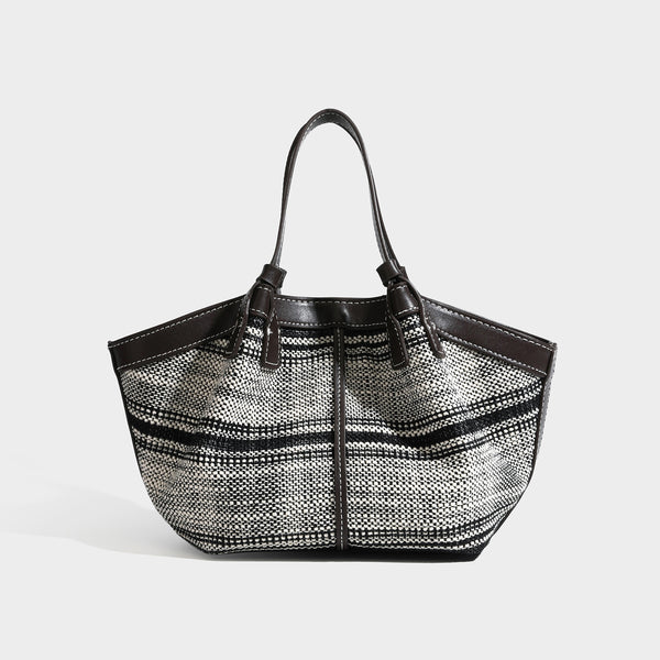 Schwarz-weiße gewebte Trapez-Tote-Bag mit dunklem Lederimitat-Besatz, weißen Kontrastnähten und zwei Henkeln, Detailansicht