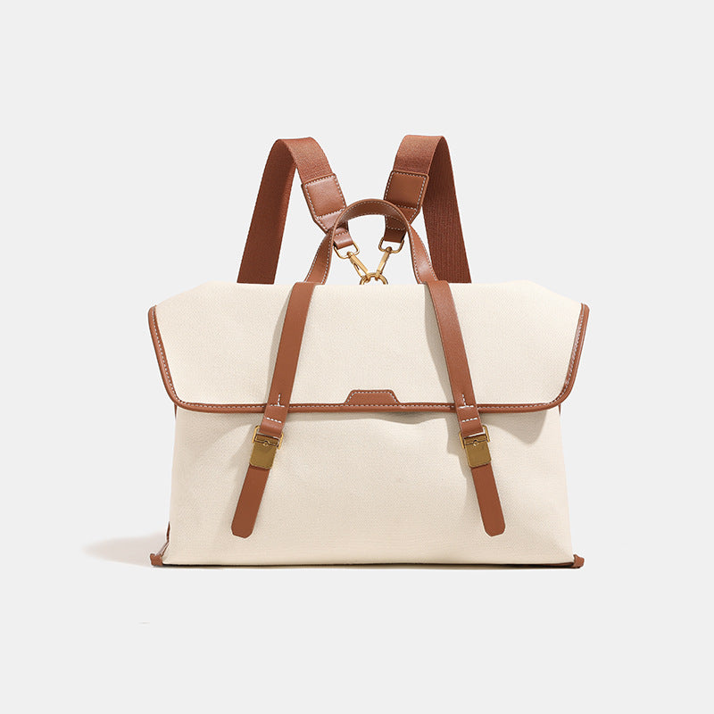 Structured flap-over backpack satchel in smooth leather-look finish with gold-tone buckle hardware and top handle, detail