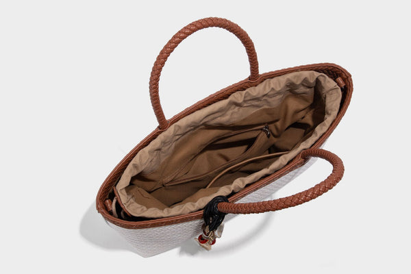 Structured woven-texture tote bag with brown braided top handles, decorative tassel charm, and detachable shoulder strap