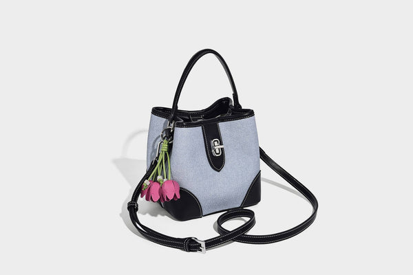 Small structured bucket bag in denim-look light blue fabric with black leather-look trim, silver turn-lock hardware, short