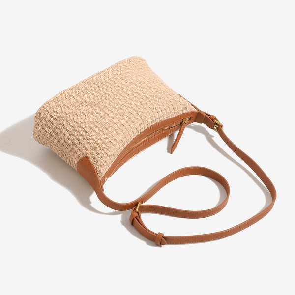 Beige woven raffia-style hobo shoulder bag with caramel leather-look trim, gold-tone zip closure, and adjustable strap
