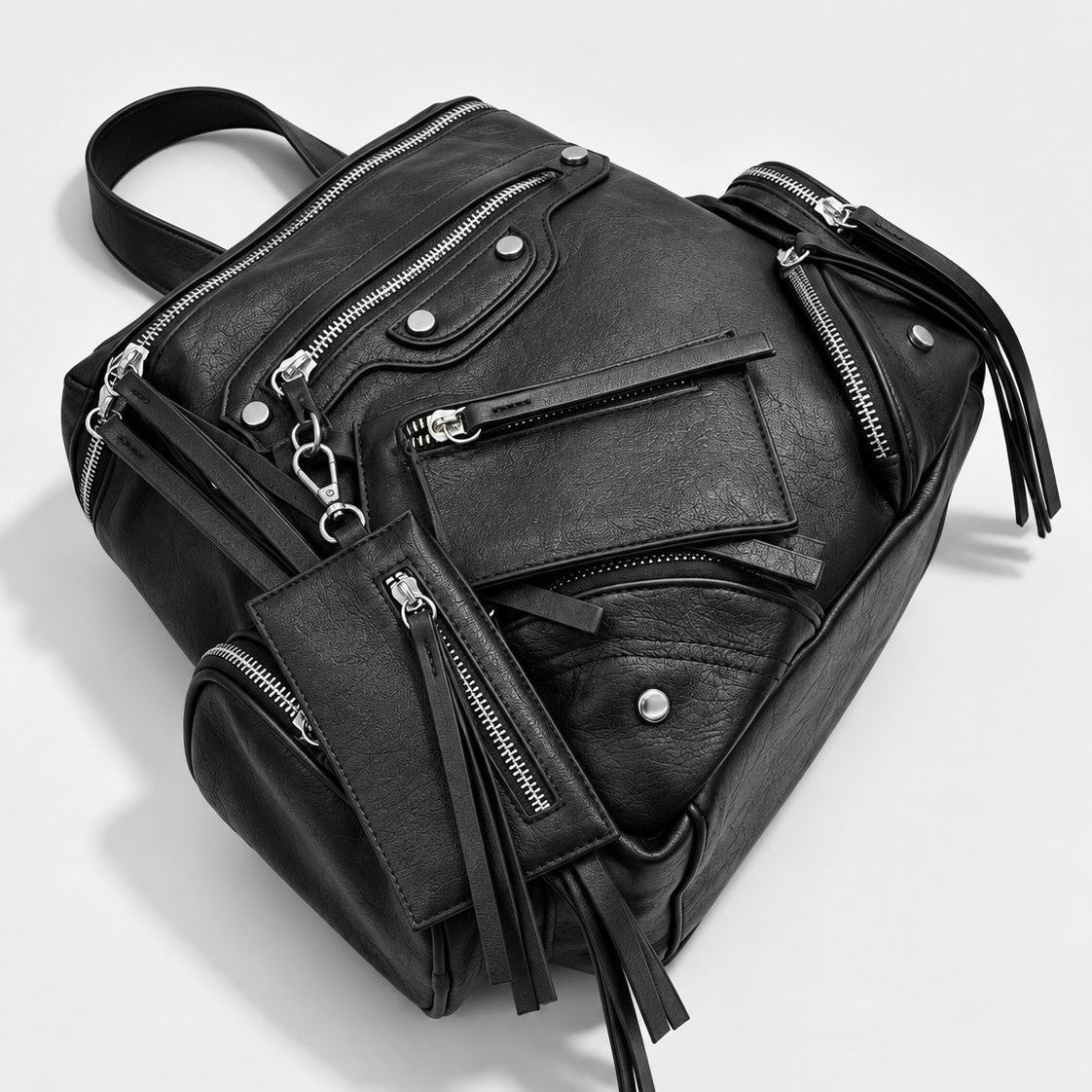 Schwarzer Rucksack in strukturierter Lederoptik mit mehreren Reißverschlussfächern in Silberoptik, Quasten-Zippern und abnehmbarem Mini-Etui