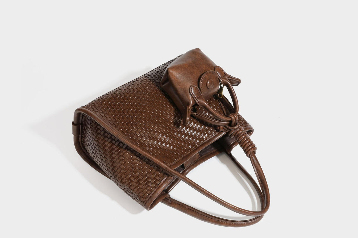 Strukturierte Tote-Bag mit Webstruktur in Braun, glattem Besatz in Lederoptik, geknoteten Henkeln und angehängtem Mini-Beutel mit Kordelzug