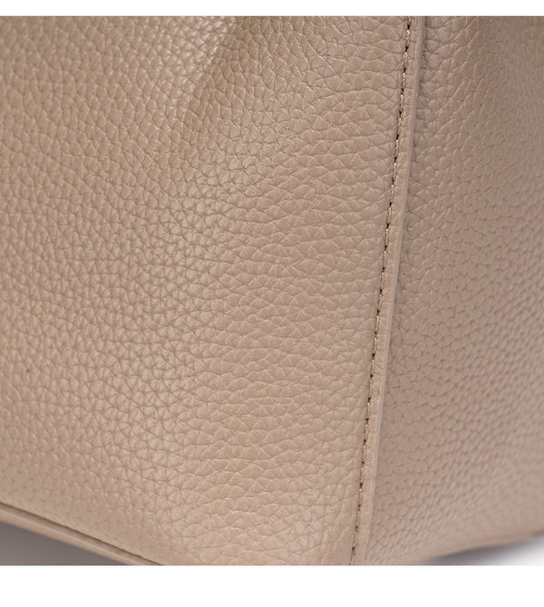 Compact structured bucket bag in pebbled leather-look finish with silver turn-lock front clasp, dual top handles, detachable