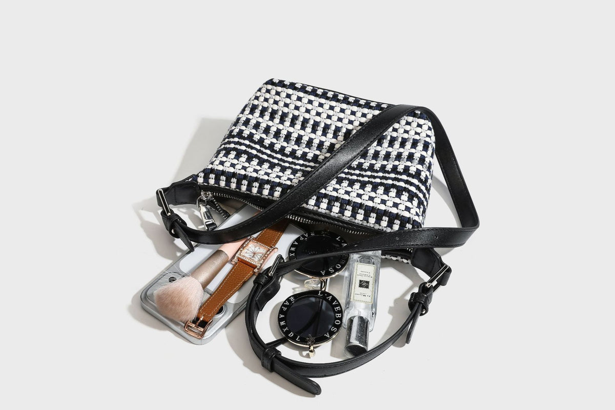 Small crescent shoulder bag in black-and-white woven textile with smooth black leather-look trim, zip-top closure, knotted
