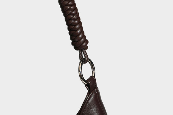 Large slouchy hobo shoulder bag with braided top handle, smooth glossy leather-look finish, and silver-tone ring hardware