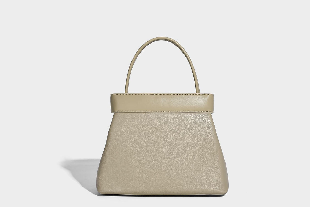 Strukturierte Trapez-Tote-Bag mit oberem Riemen mit Gürtelschnalle, genarbter Lederoptik und silberfarbenen Beschlägen, Detailansicht