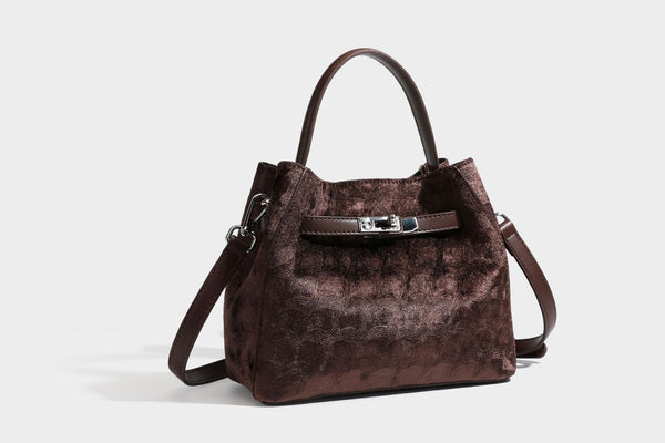 Small structured bucket satchel in embossed velvet-texture fabric with silver turn-lock hardware, rounded top handle, and