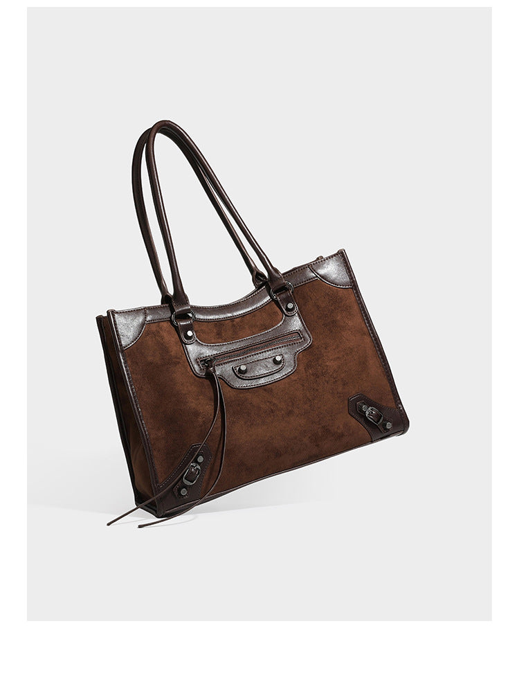 Large structured tote bag with matte suede-like body, smooth leather-look trim, front zip pocket, stud hardware, and