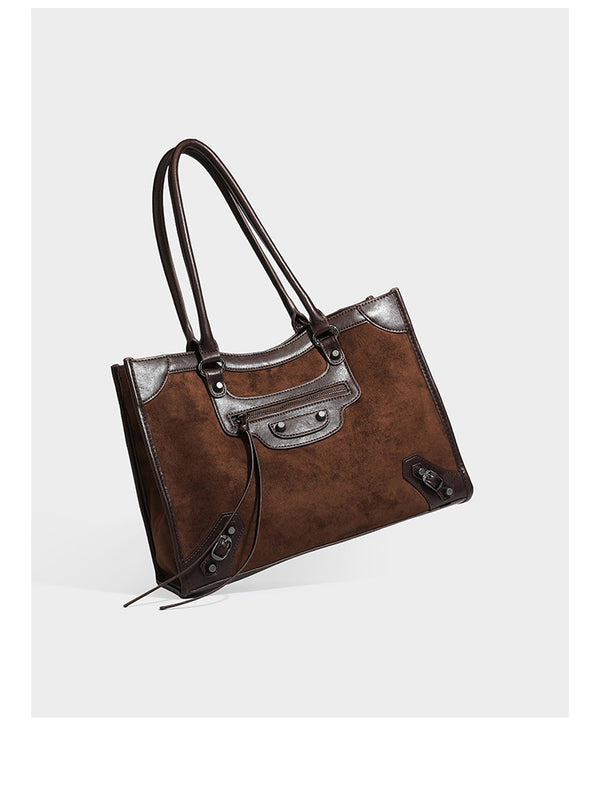 Large structured tote bag with matte suede-like body, smooth leather-look trim, front zip pocket, stud hardware, and