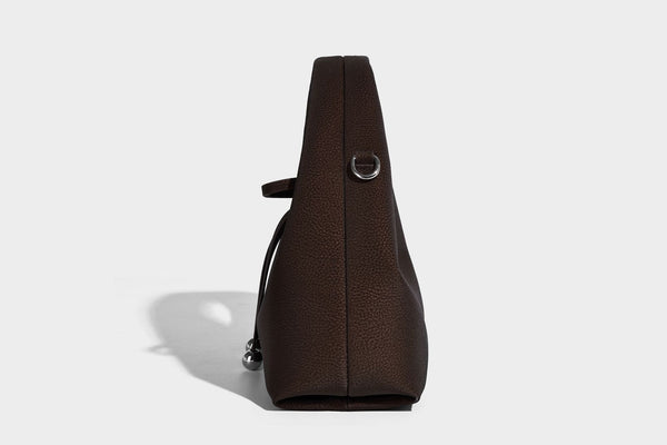 Pebbled matte trapezoid top-handle bag with drawstring bow closure, bead-tipped cords, silver-tone hardware, and detachable