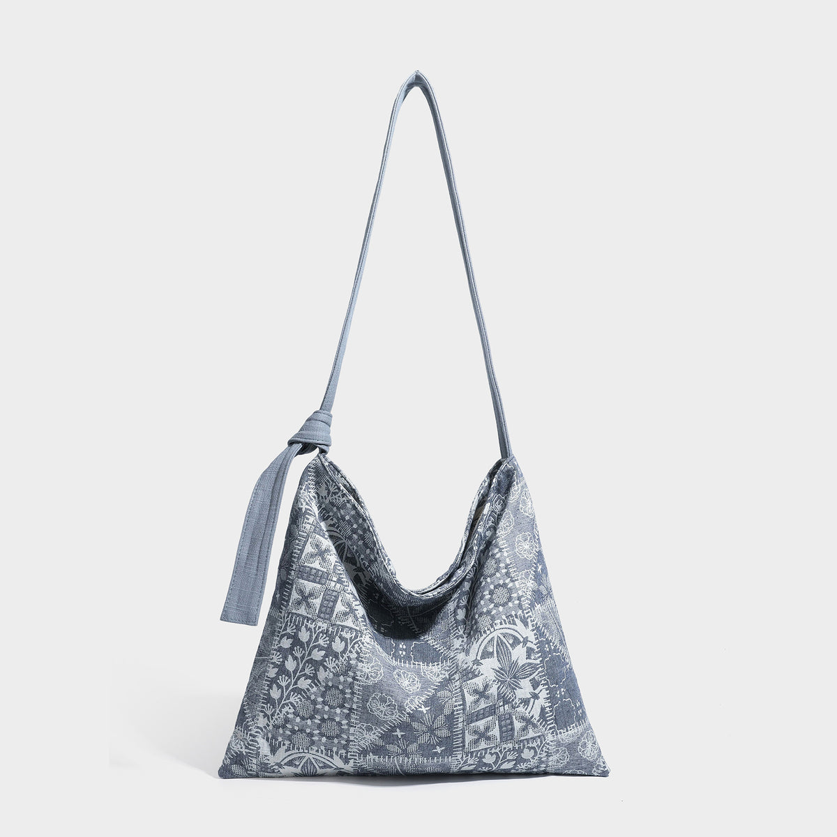 Lässig geschnittene Hobo-Schultertasche aus Canvas mit botanischem Print, langem geknotetem Trageriemen und Reißverschluss oben, Detailansicht 3