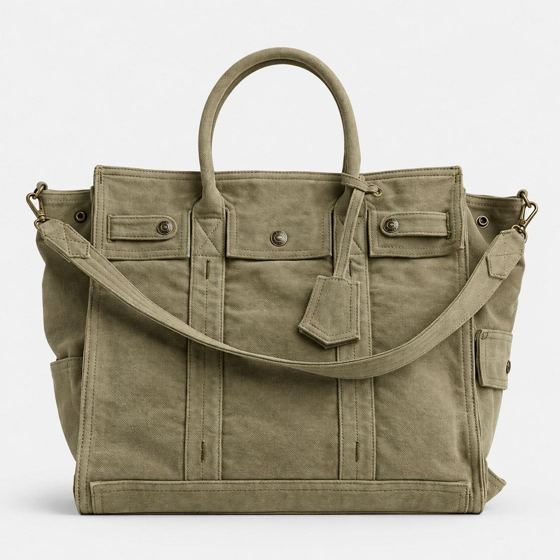 Large washed denim patchwork tote bag with snap-flap front pockets, rolled handles, and detachable shoulder strap, detail