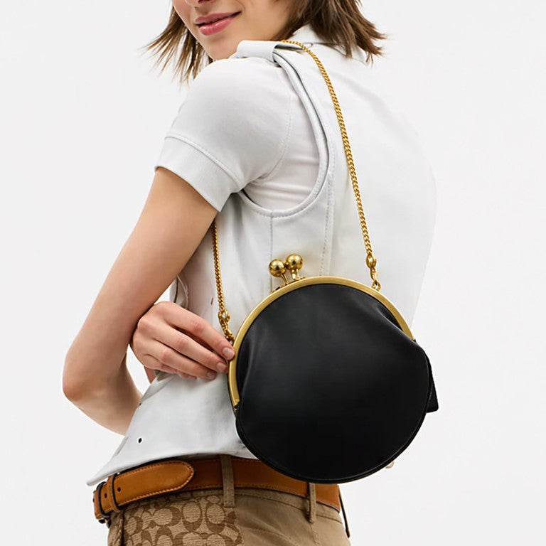 Round kiss-lock clutch bag with gold-toned frame and ball knobs, front view