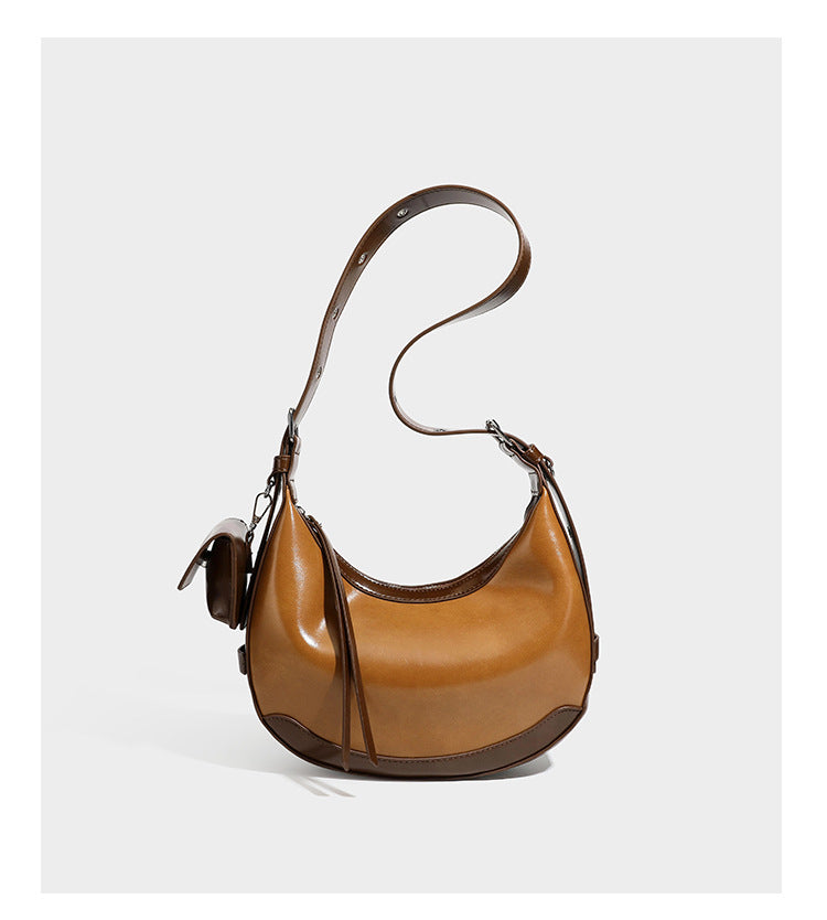 Glossy leather-look crescent hobo shoulder bag with dark contrast trim, silver-tone hardware, and attached mini flap pouch