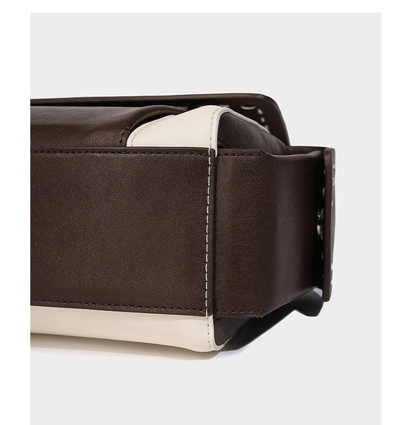 Structured flap crossbody bag in dark brown and cream color-block with white contrast stitching, adjustable shoulder strap
