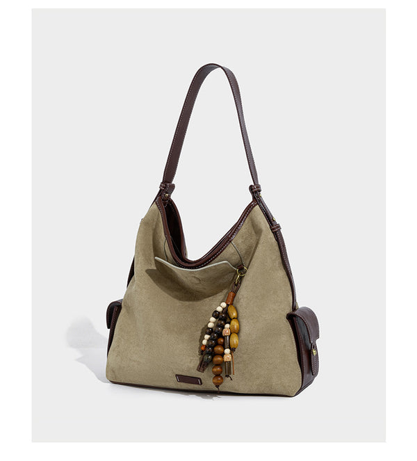 Lässig fallende Hobo-Schultertasche in Khaki aus mattem Material in Wildlederoptik mit dunkelbraunem Besatz in Lederoptik, Quastenanhänger mit Perlen und seitlicher Klappe, Detailansicht