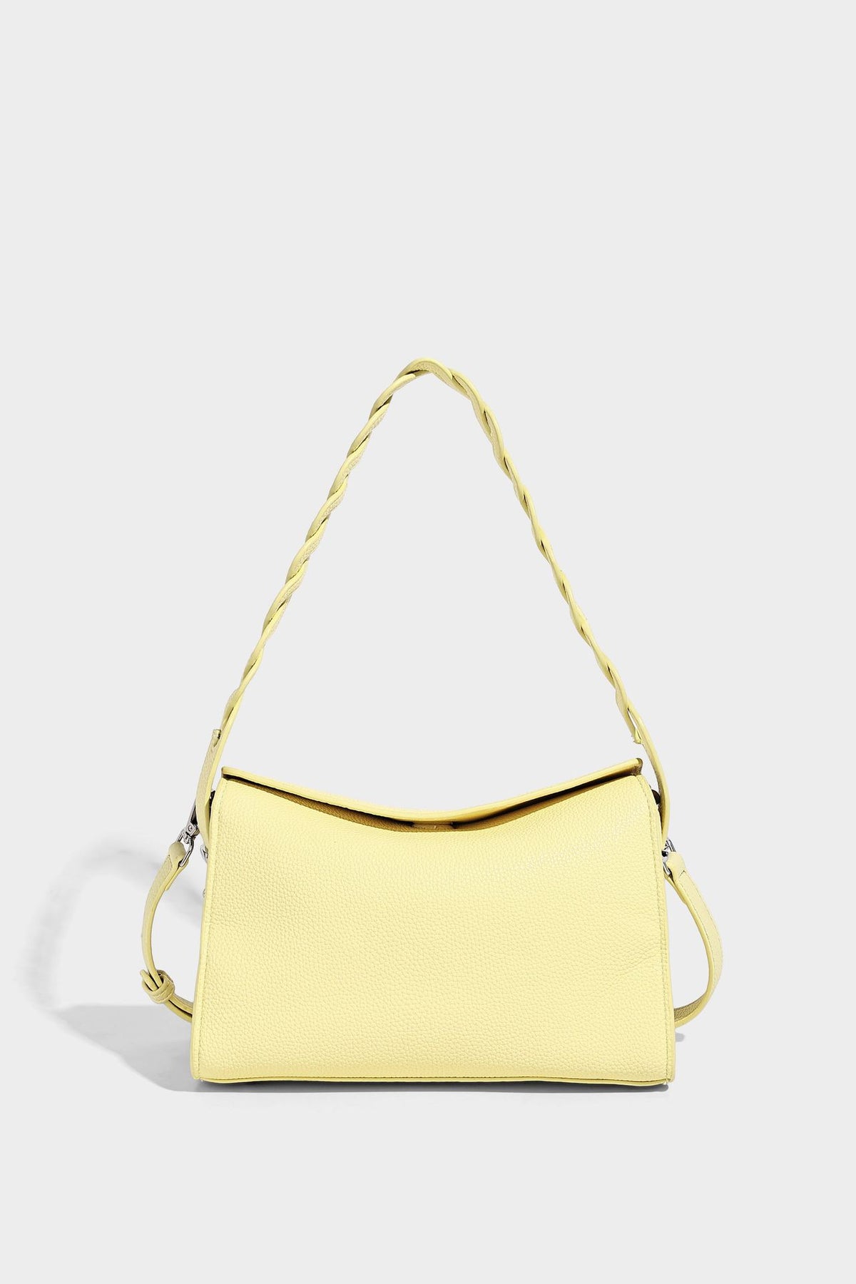 Small structured pebbled-finish shoulder bag with braided top handle, detachable crossbody strap, floral tassel charm, and