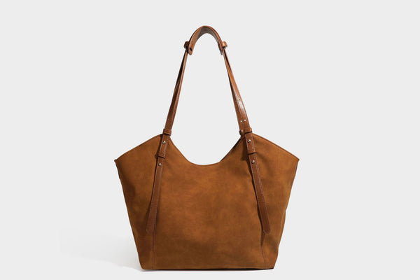Oversized suede-finish tote shoulder bag in caramel brown with slim leather-look straps and gold-tone logo hardware, detail