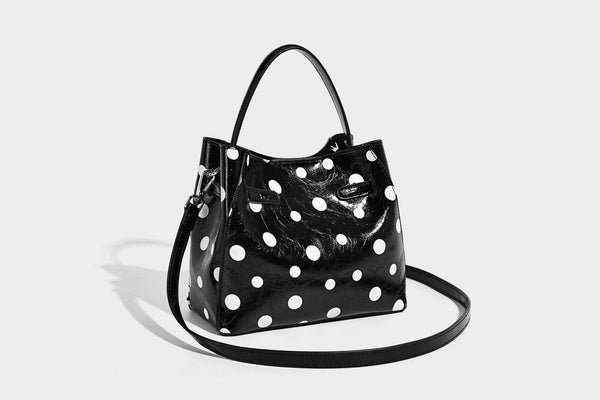 Glänzende, geknautschte Beuteltasche mit Polka-Dots, silberfarbenen Schnallenbeschlägen, kontrastierendem seitlichem Schnürbesatz, Tragegriff und abnehmbarem
