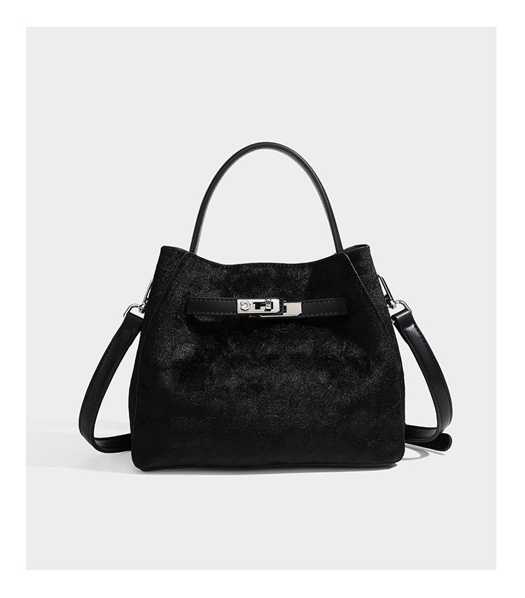 Small structured bucket satchel in embossed velvet-texture fabric with silver turn-lock hardware, rounded top handle, and