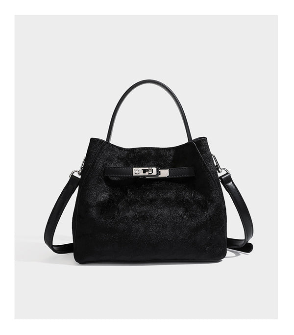 Small structured bucket satchel in embossed velvet-texture fabric with silver turn-lock hardware, rounded top handle, and