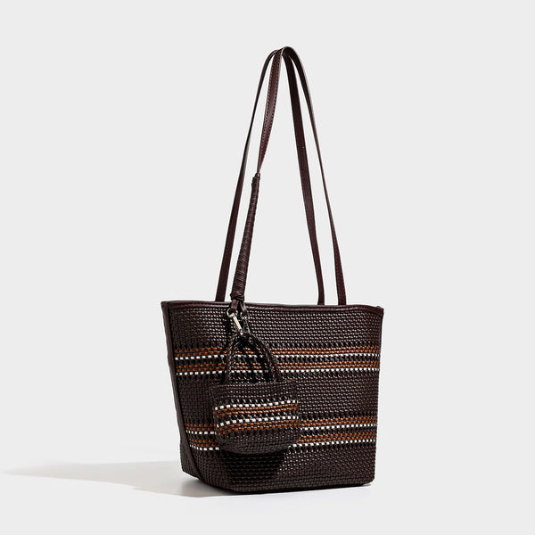 Large structured woven tote bag with striped basket-weave finish, long shoulder straps, and detachable mini pouch charm