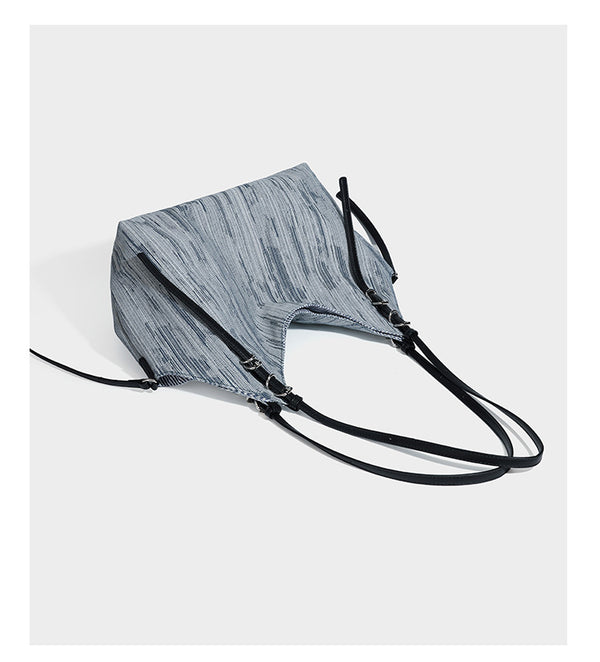 Large slouchy woven-texture shoulder tote bag with slim leather-look straps, side cinch ties, and silver-tone hardware