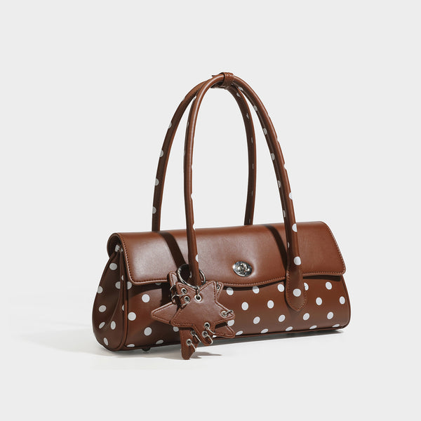 Formstabile Baguette-Tasche mit Polka-Dot-Muster, glänzender Oberfläche in Lederoptik, zwei Tragegriffen, silberfarbenem Drehverschluss an der Umschlagklappe und