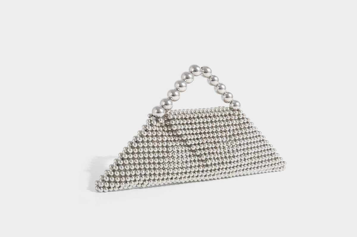 Small structured triangle clutch bag covered in glossy pearl beads with an arched pearl top handle and silver snap closure