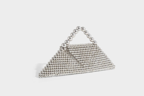 Small structured triangle clutch bag covered in glossy pearl beads with an arched pearl top handle and silver snap closure