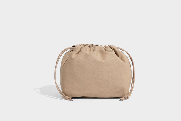 Glänzende, geknautschte Beuteltasche mit Polka-Dot-Muster, silberfarbenen Schnallenbeschlägen, kontrastierendem seitlichem Schnürbesatz, Tragegriff und abnehmbarem