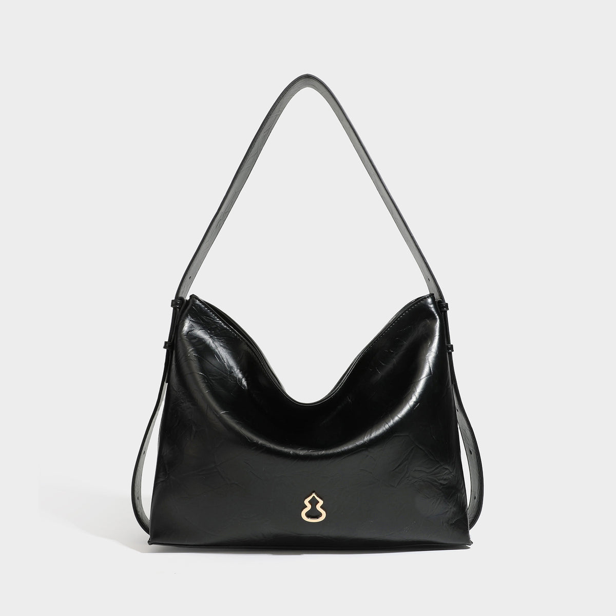 Lässig-sackförmige Hobo-Schultertasche mit offenem oberen Rand in glänzender karamellfarbener Lederoptik, goldfarbenen Logo-Beschlägen und langem verstellbarem