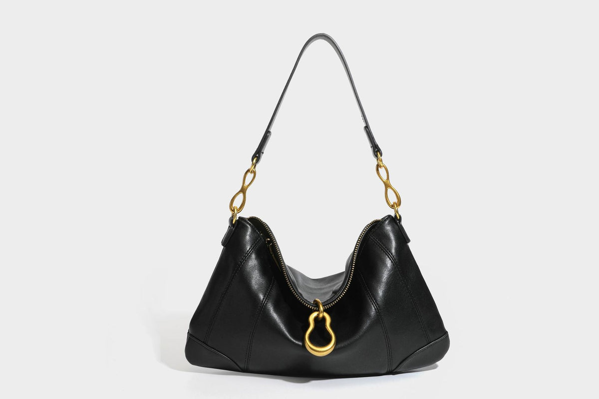 Slouchy denim shoulder bag with dark leather-look trim, gold-tone chain-link hardware, and top zipper closure, detail view 19