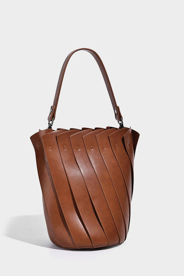 Structured pleated-panel bucket bag with curved top handle and detachable adjustable shoulder strap in smooth matte, detail