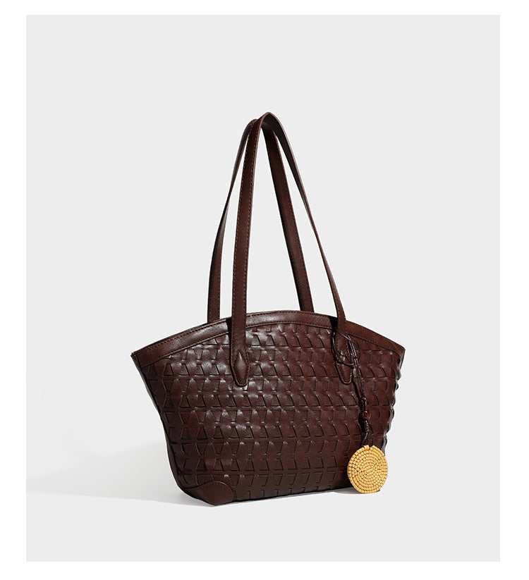 Large leather-look tote bag with geometric woven emboss, double shoulder straps, and round woven cord charm in brown, detail